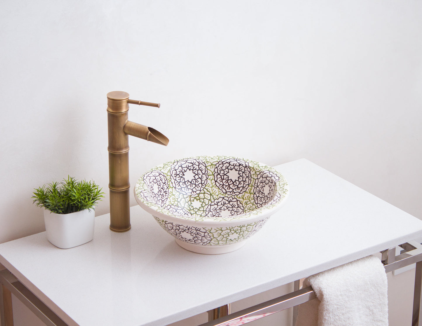 Handmade ceramic sink photographed from side angle showing geometric pattern detail in bathroom setting