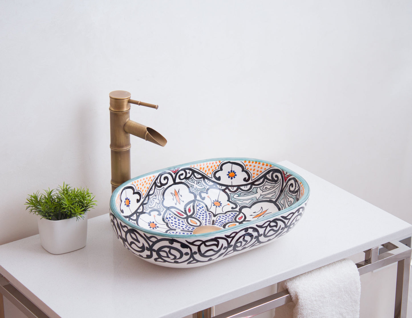 Handcrafted oval sink photographed from side angle showcasing interior floral patterns