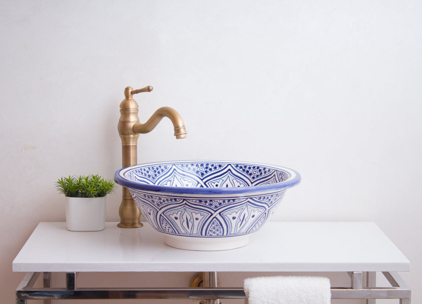 Front lifestyle view of handcrafted ceramic sink with brass fixture in minimalist bathroom design