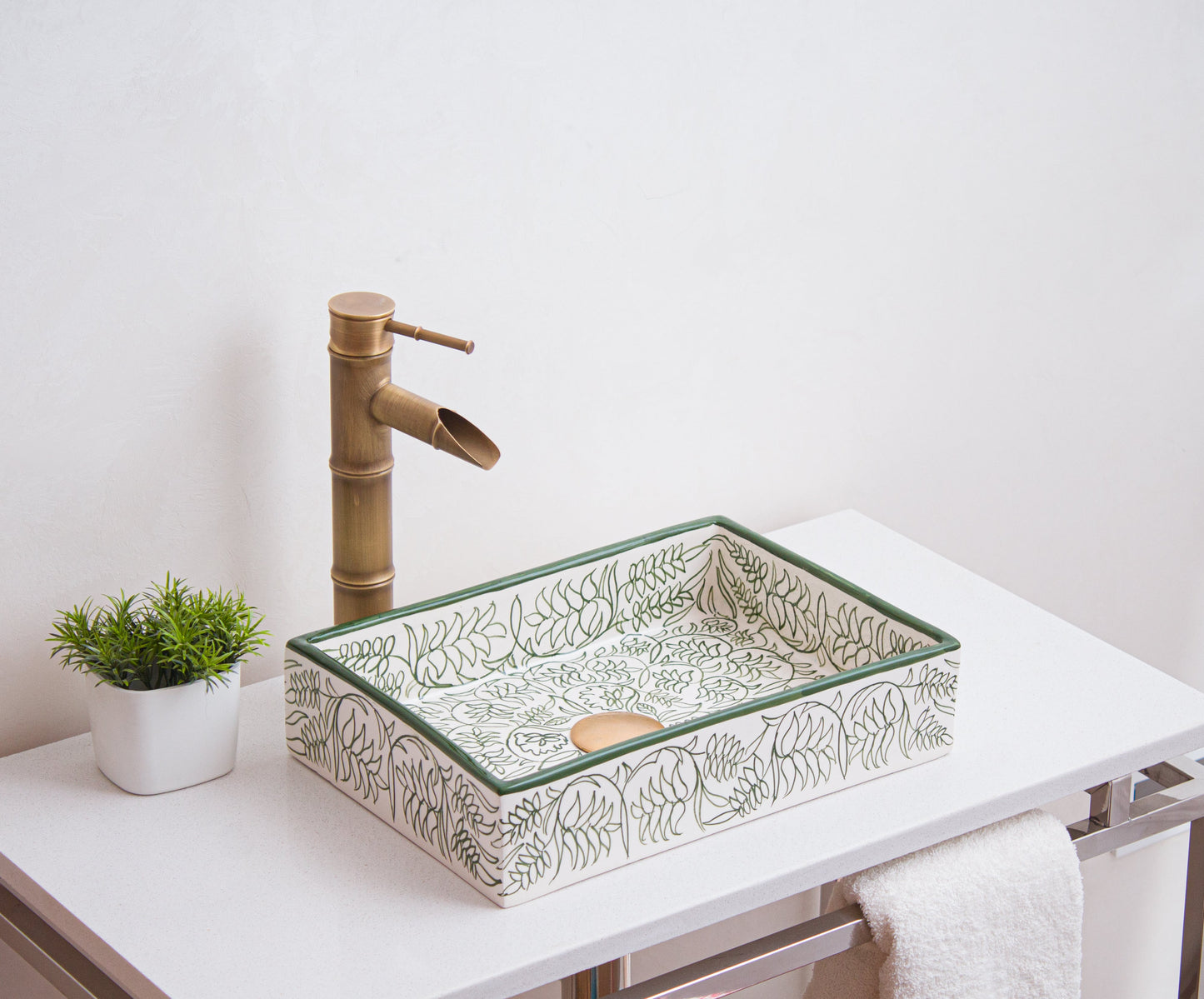 Artisanal ceramic vessel sink featuring intricate floral line drawings positioned on modern bathroom vanity with brass fixtures