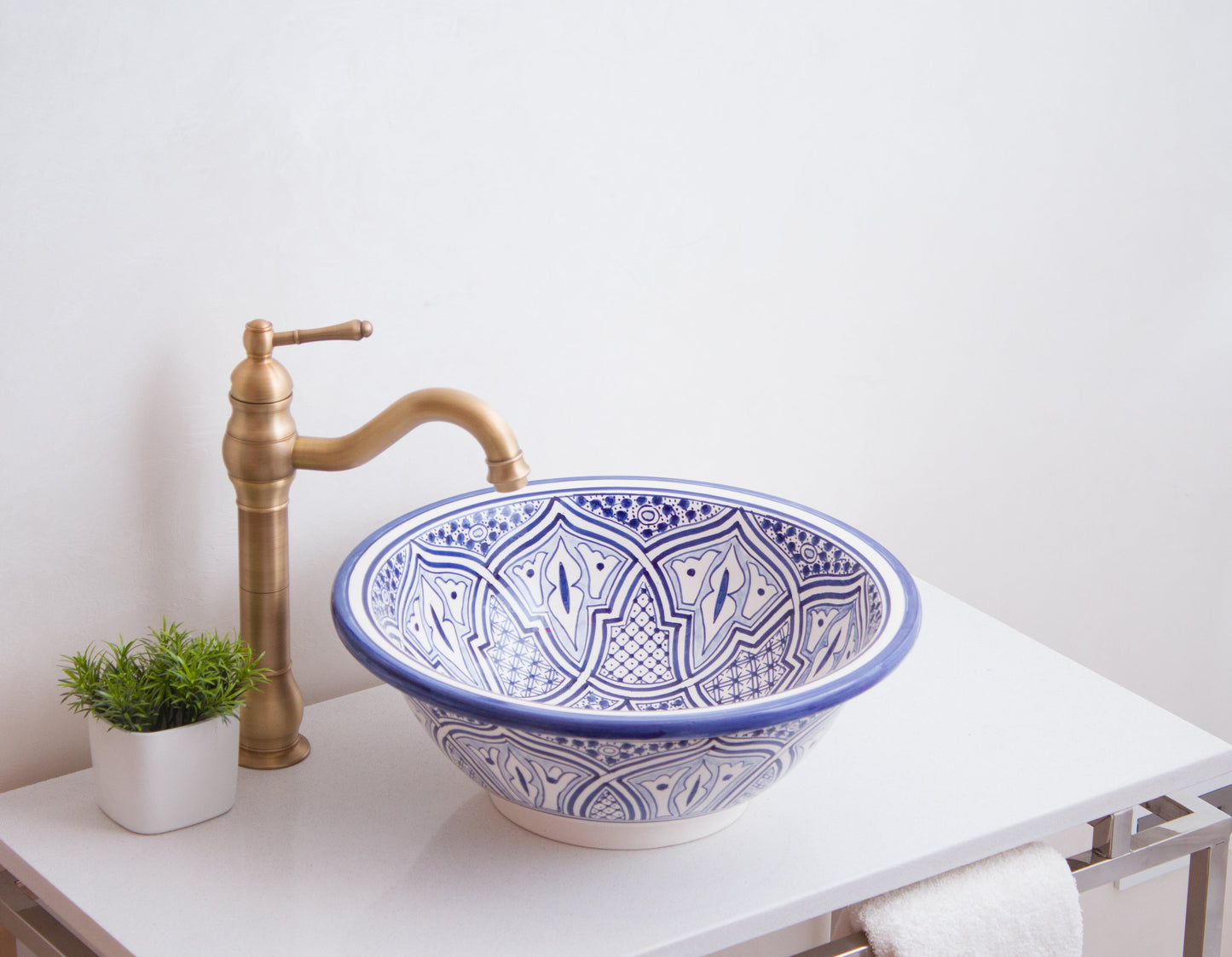 Moroccan vessel sink photographed from side angle with curved brass faucet in contemporary bathroom setting