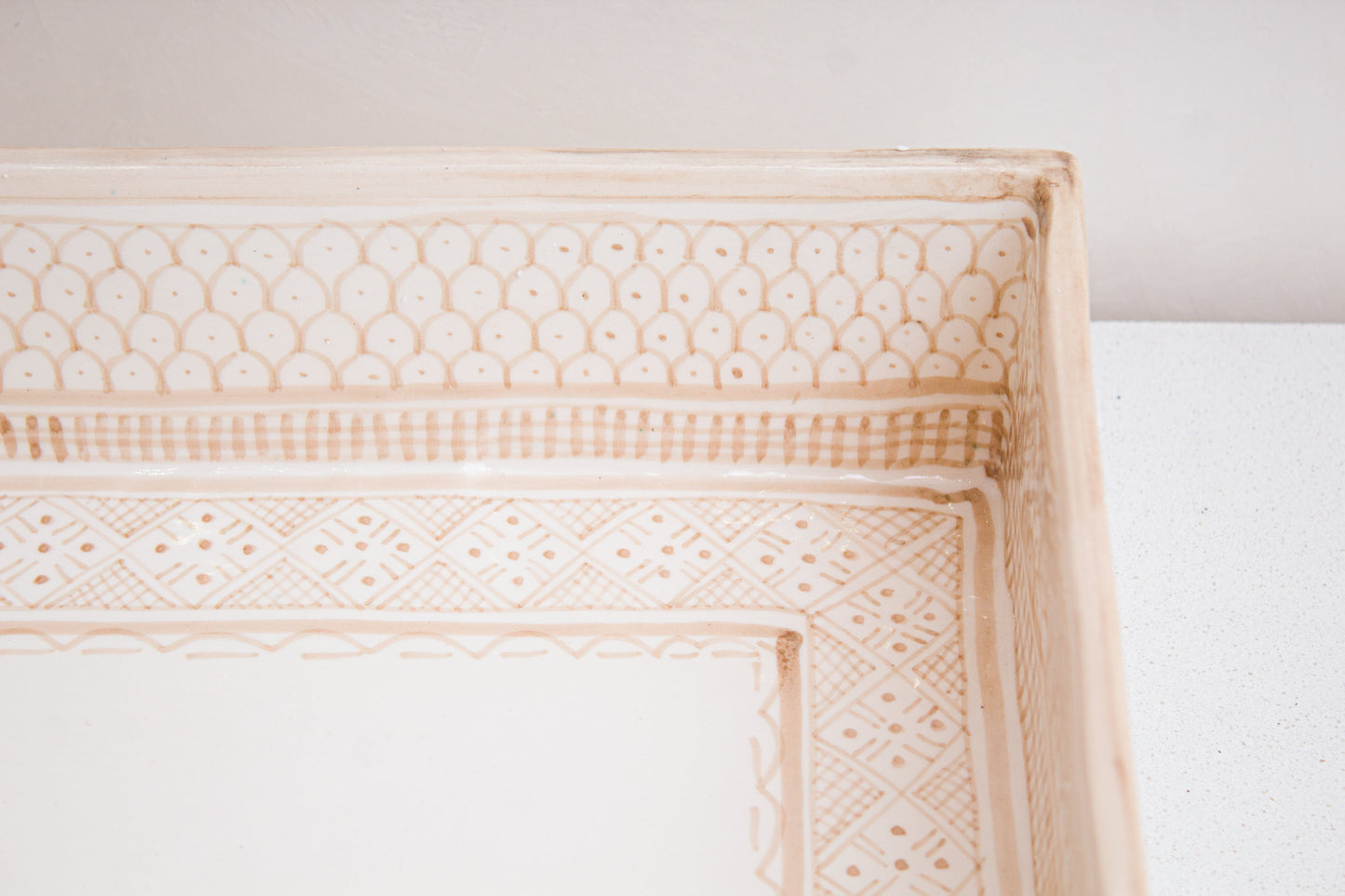 Detailed view of corner geometric motifs showing traditional Moroccan beige and white patterns