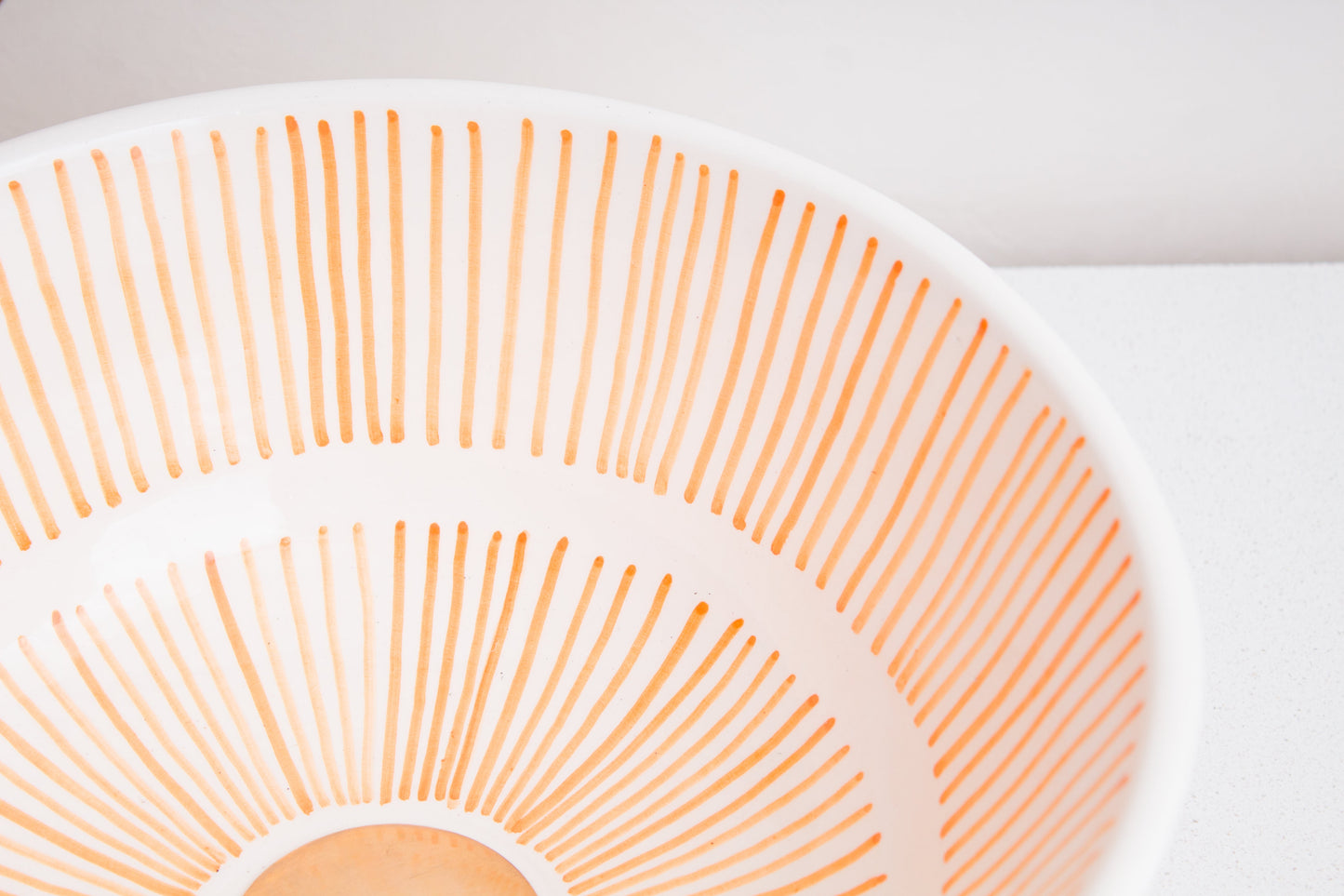 Angled interior view of Moroccan ceramic sink showcasing orange radial sunburst pattern radiating from center