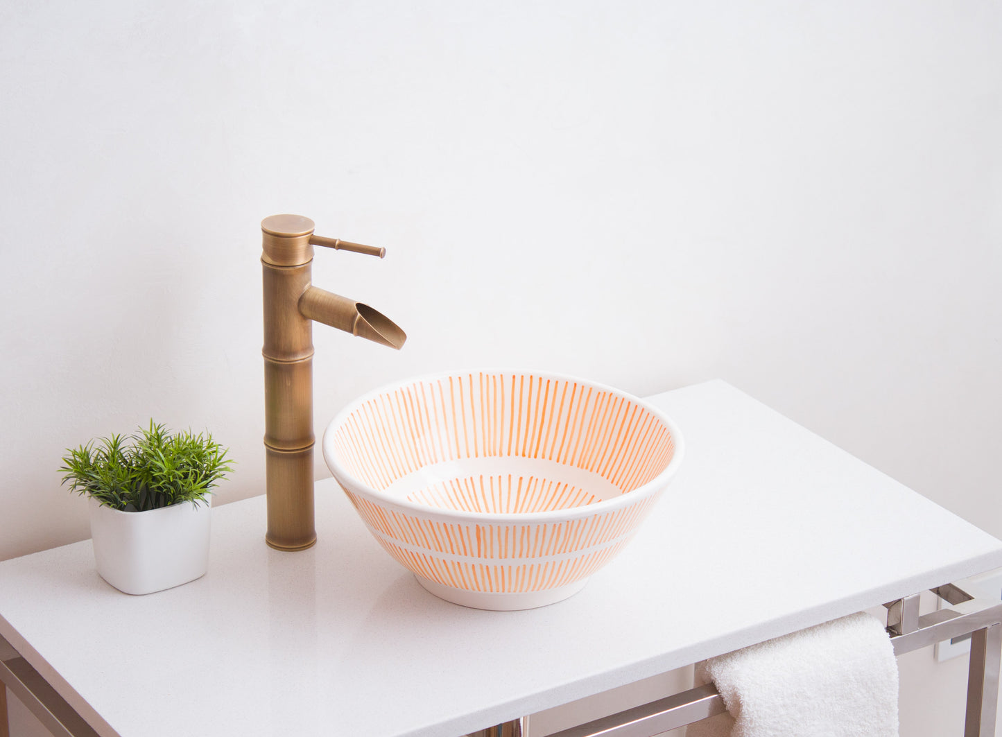 Handmade ceramic vessel sink positioned on contemporary bathroom counter with brass faucet in modern bathroom setting
