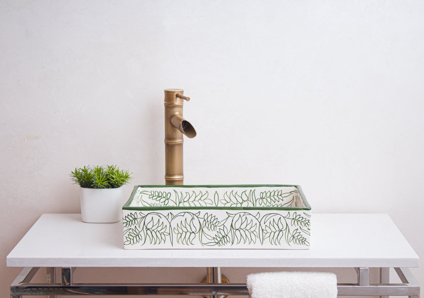 Side view of handmade rectangular ceramic sink showcasing botanical border patterns in bathroom setting with bamboo-style faucet