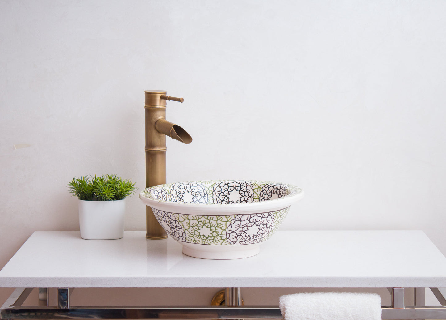 Front view of decorative Moroccan basin positioned on modern bathroom vanity with brass fixtures