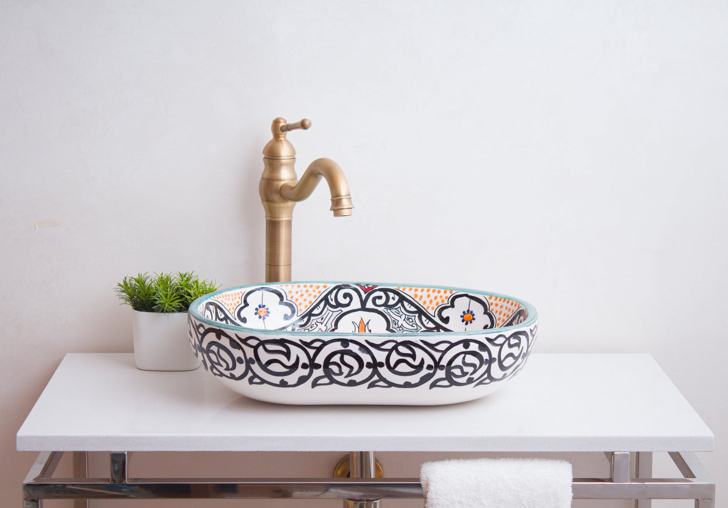 Front lifestyle view of oval vessel sink with traditional brass faucet in bathroom setting