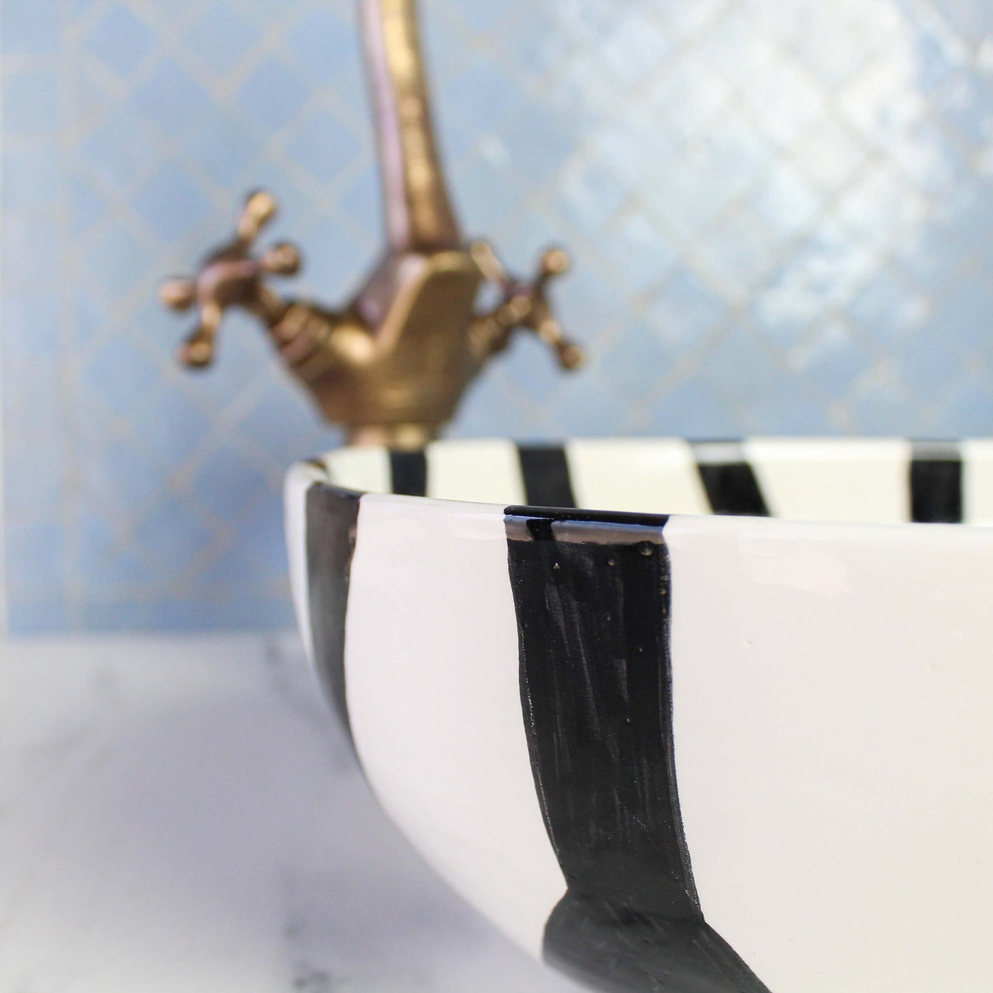 Close-up detail of black and white striped ceramic sink edge