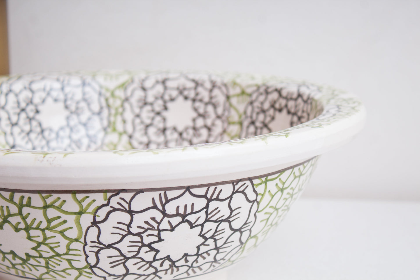 Close-up detail of intricate mandala and geometric patterns on ceramic basin rim and exterior
