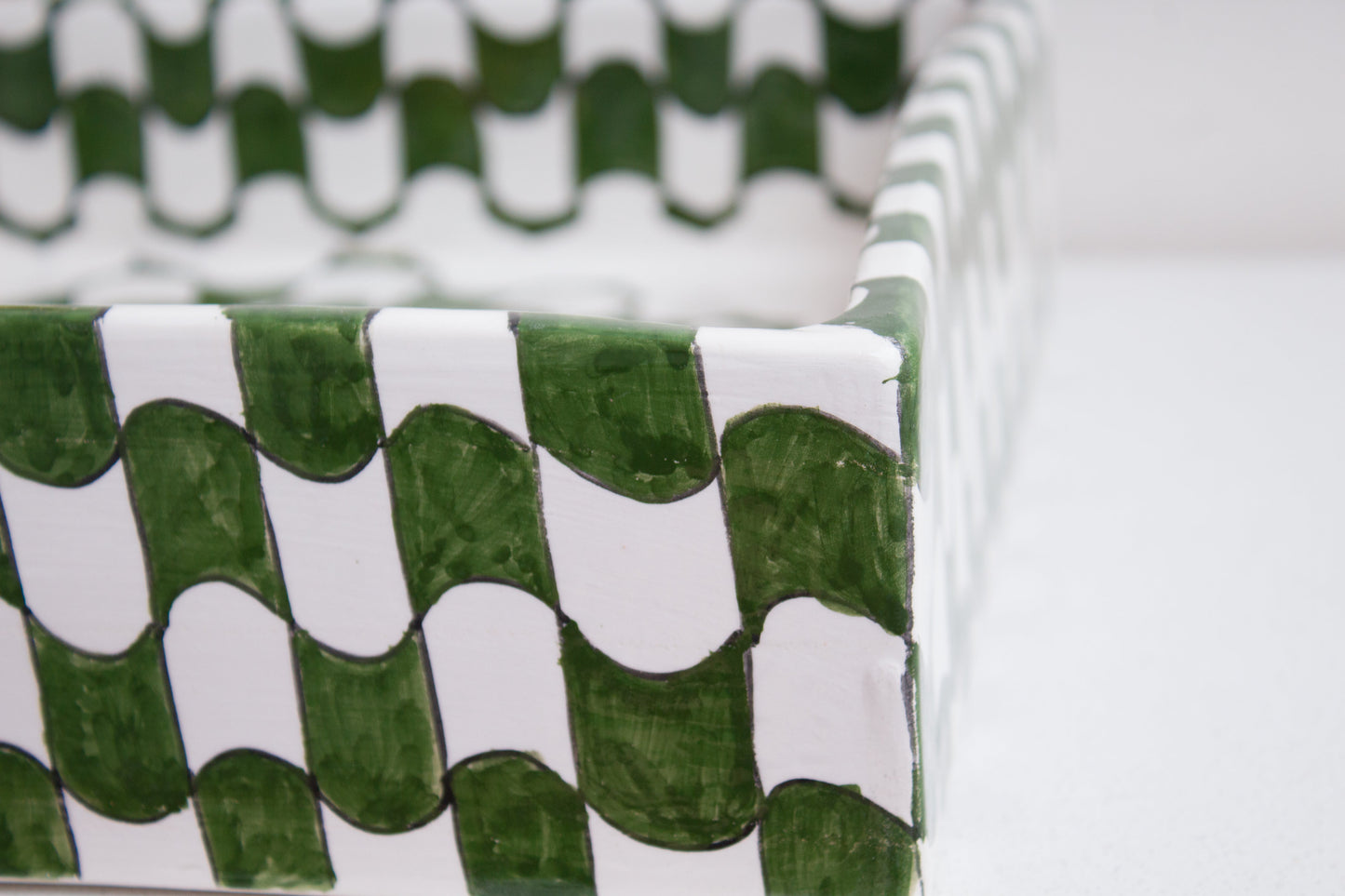 detail of green and white geometric pattern along the rim edge of handcrafted ceramic basin