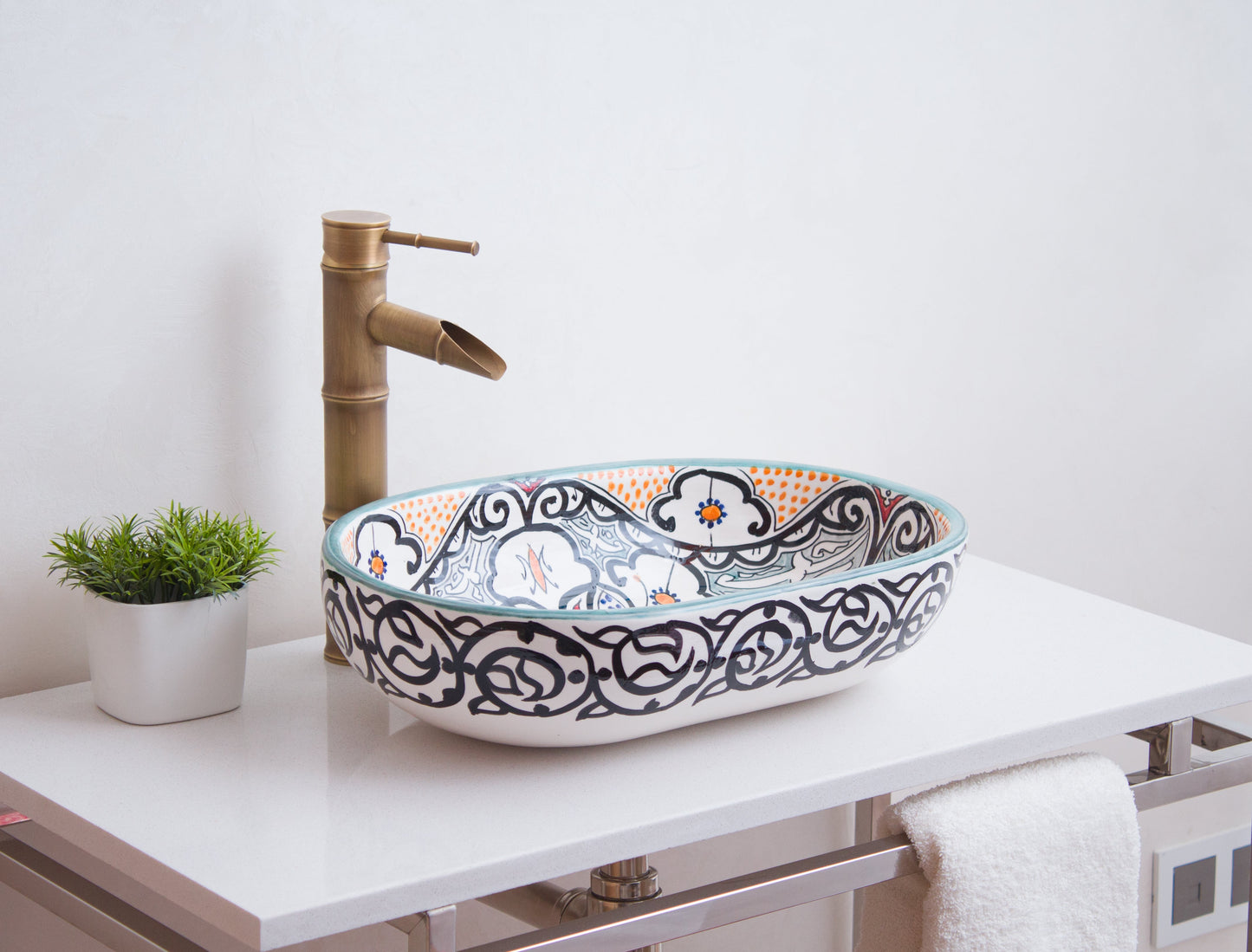 Moroccan oval ceramic basin styled with brass bamboo faucet on white modern vanity