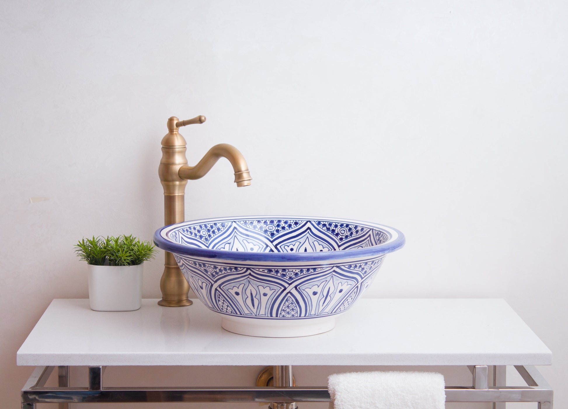 Front lifestyle view of handcrafted ceramic sink with brass fixture in minimalist bathroom design