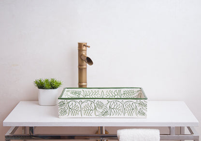 Side view of handmade rectangular ceramic sink showcasing botanical border patterns in bathroom setting with bamboo-style faucet