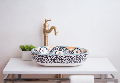 Front lifestyle view of oval vessel sink with traditional brass faucet in bathroom setting