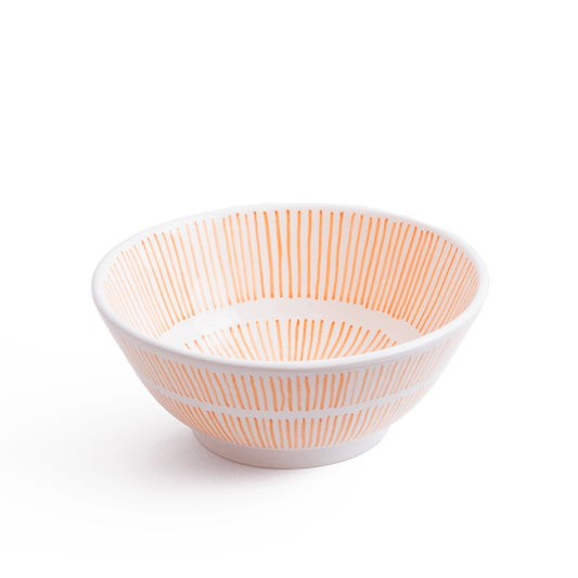 Three-quarter perspective view of handcrafted round ceramic basin featuring orange and white radial sunburst line design
