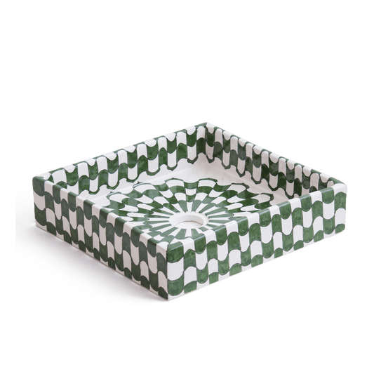 perspective view of handcrafted square ceramic basin featuring green and white geometric pattern with radial design