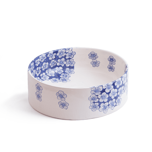 Three-quarter perspective view of ceramic vessel sink with blue flower motifs on white background showing complete bowl shape and decorative pattern