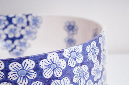 Close-up detail of ceramic vessel sink rim highlighting the hand-painted blue floral pattern and delicate flower motifs