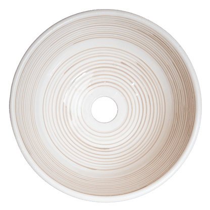 Top-down interior view of cream ceramic vessel sink showing concentric spiral ridges and central drain opening